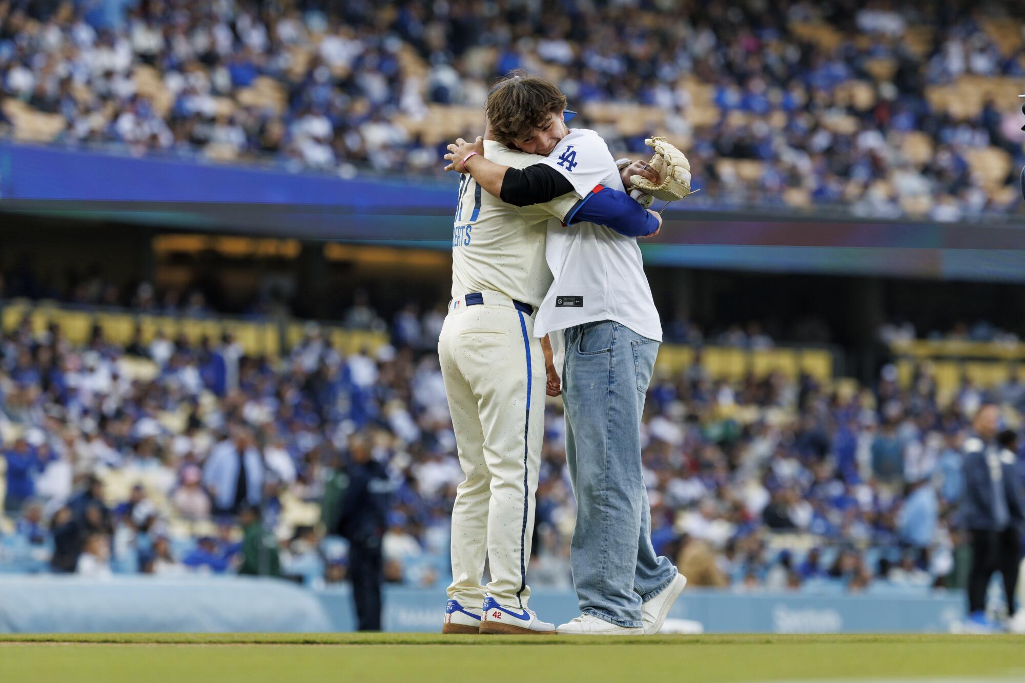 Dodgers manager Dave Roberts hugs Palisades Charter High School baseball pitcher Jett Teegardin