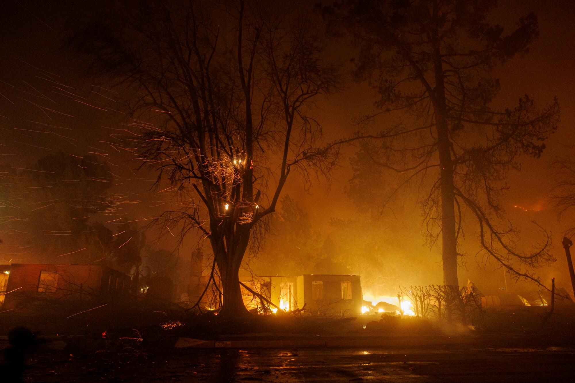 Embers fly above a burning building.