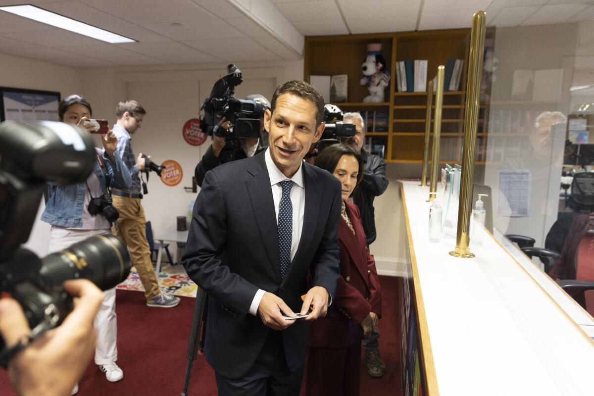 Daniel Lurie, wearing a dark suit, files paperwork required to participate in San Francisco's mayoral election.
