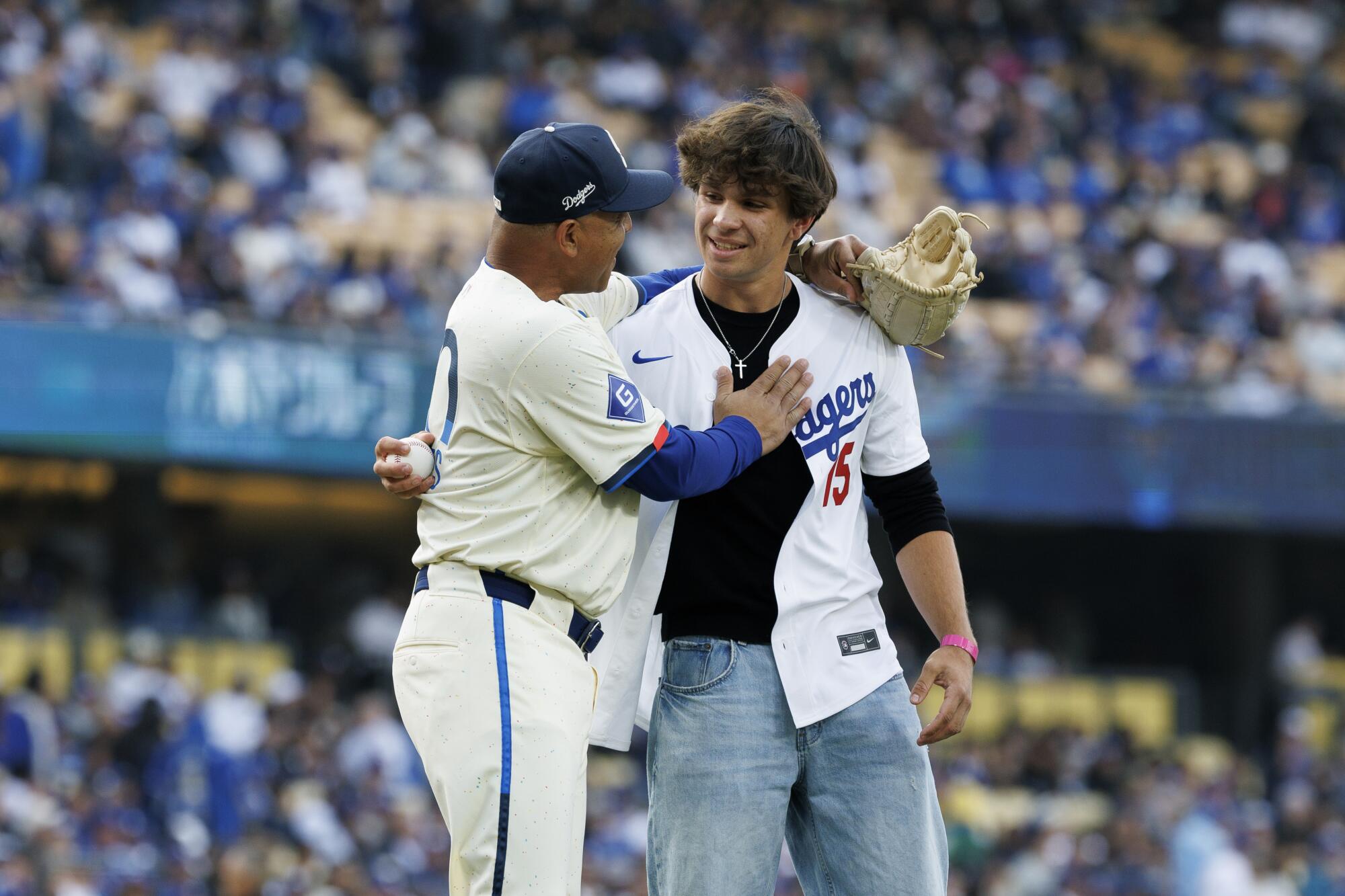 Dave Roberts embraces Palisades Charter High pitcher Jett Teegardin, who threw out the first pitch at Dodger Stadium