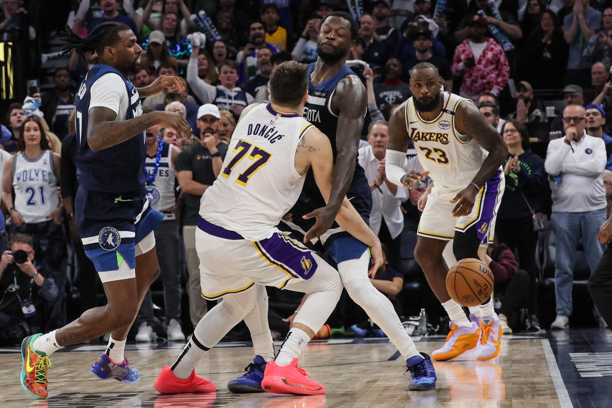 Lakers guard Luka Doncic tries to pass to LeBron James under pressure from the Timberwolves