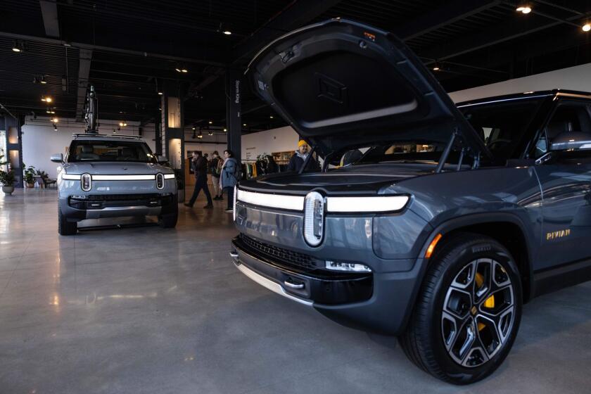 A Rivian R1T electric vehicle (EV) pickup truck, left, and R1S electric sports utility vehicle (SUV) at the company's showroom in New York.