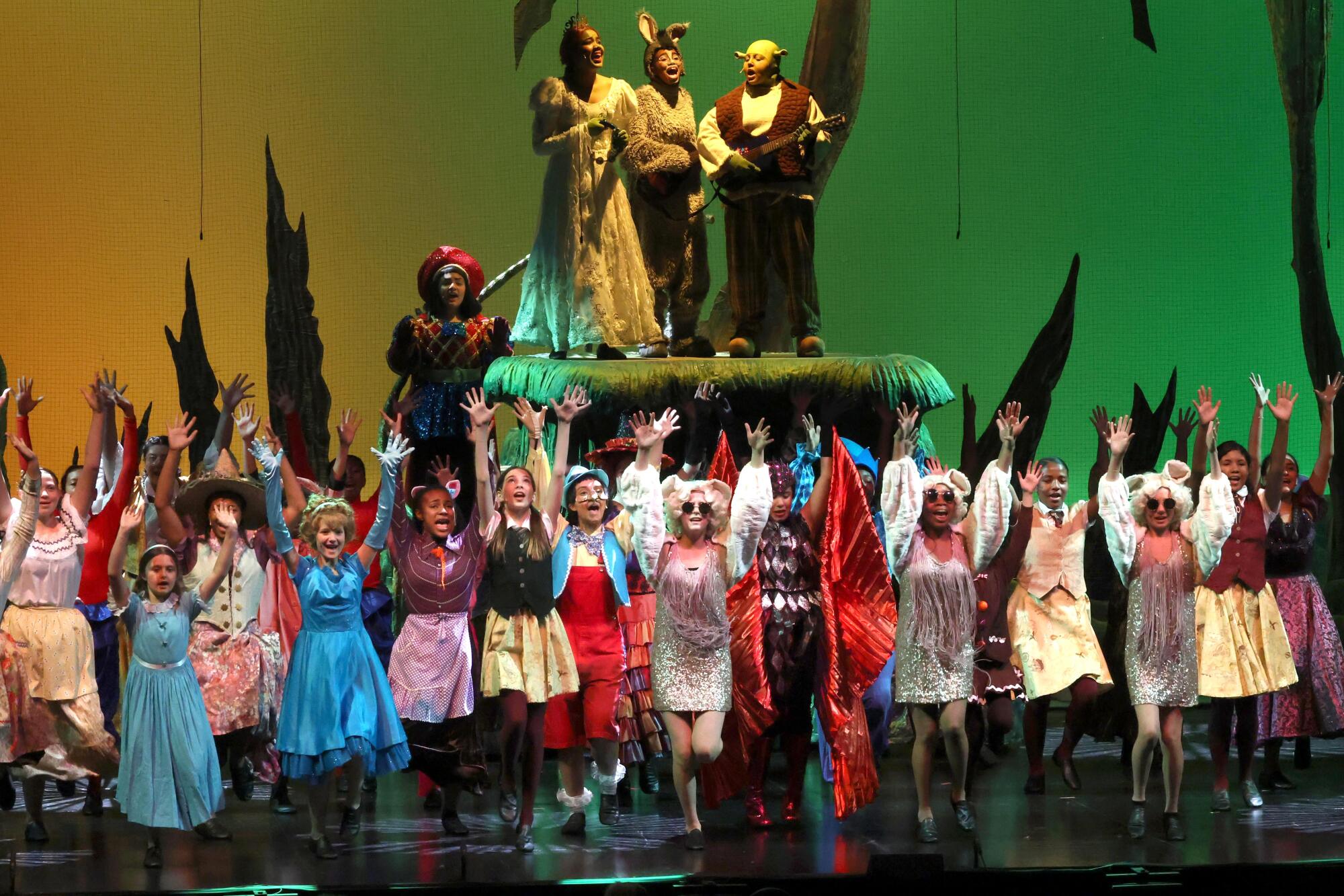 Altadena and Eliot Arts magnet performers in colorful costumes perform "Shrek the Musical Jr." at the Ahmanson Theatre.