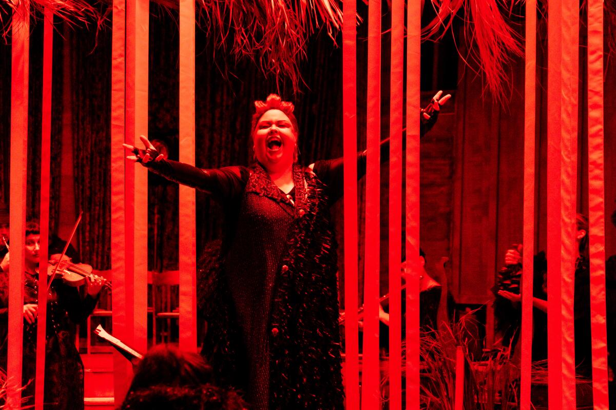 Mezzo-soprano Jamie Barton is bathed in red stage light in Long Beach Opera's "El Relicario de Los Animales."