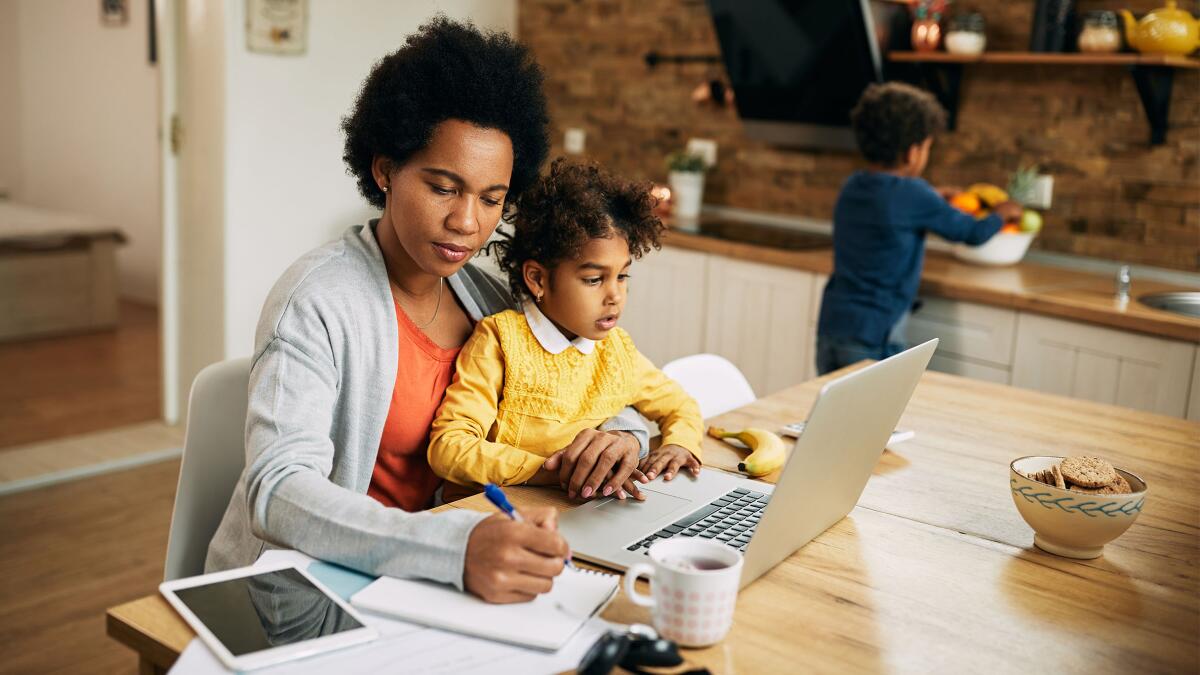 Mother of one sick and another healthy child takes notes from a doctor at home.