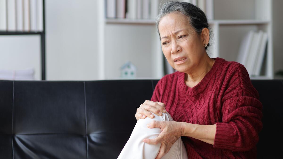 Senior woman with Rheumatoid Arthritis leg pain in anguish and considering a trip to the ER.