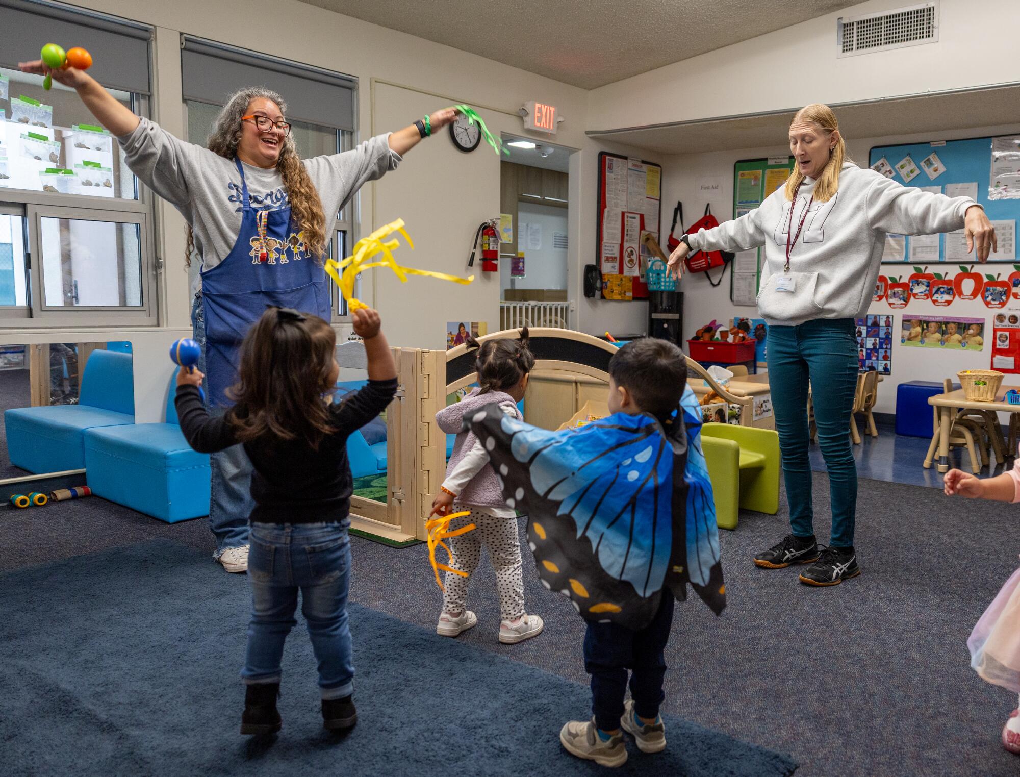 Two women dance with children in the Early Head Start program at Pacific Clinics Early Head Start Center in Pasadena.