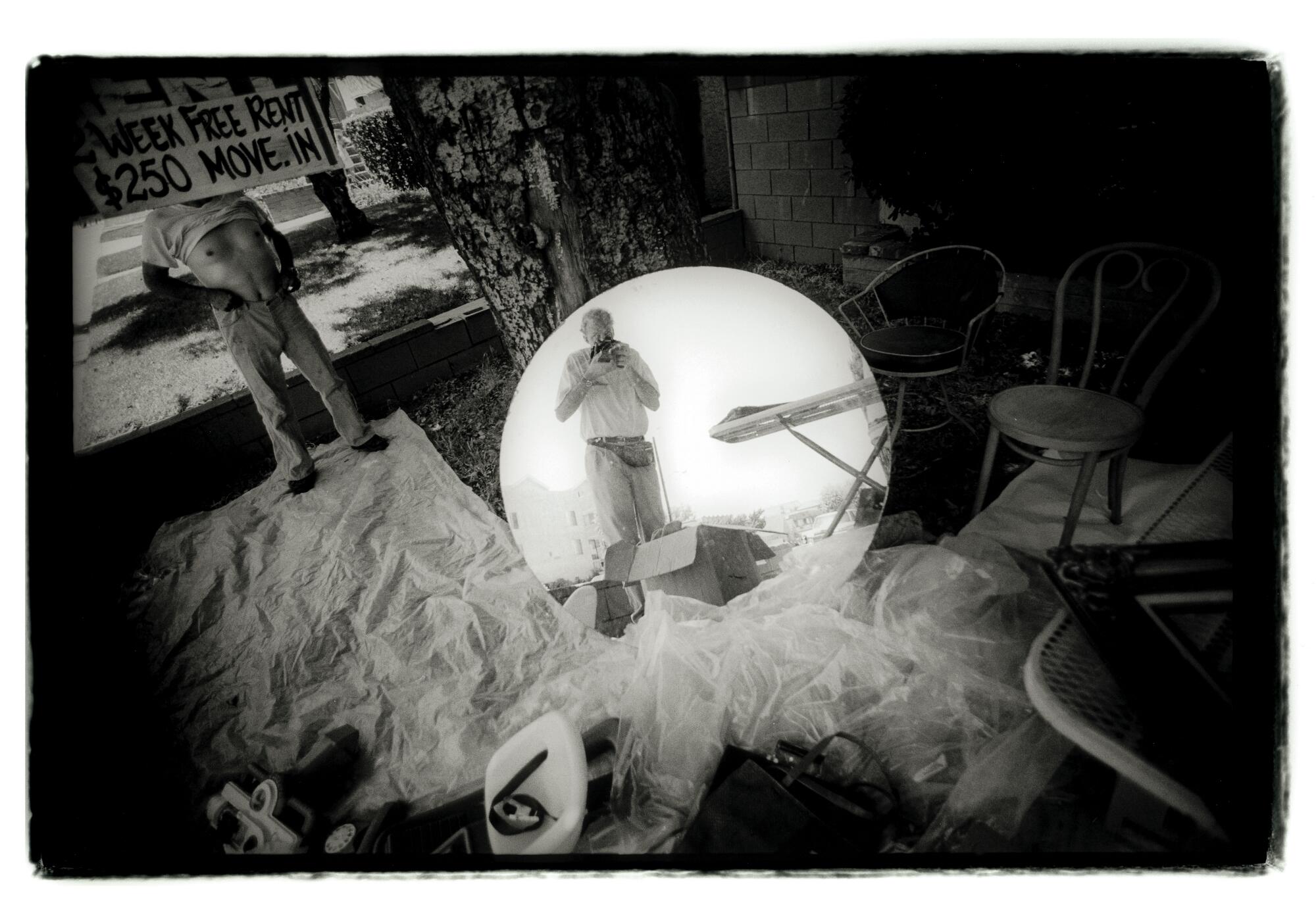 Black and white image showing Douglas McCulloh in a round mirror's reflection.