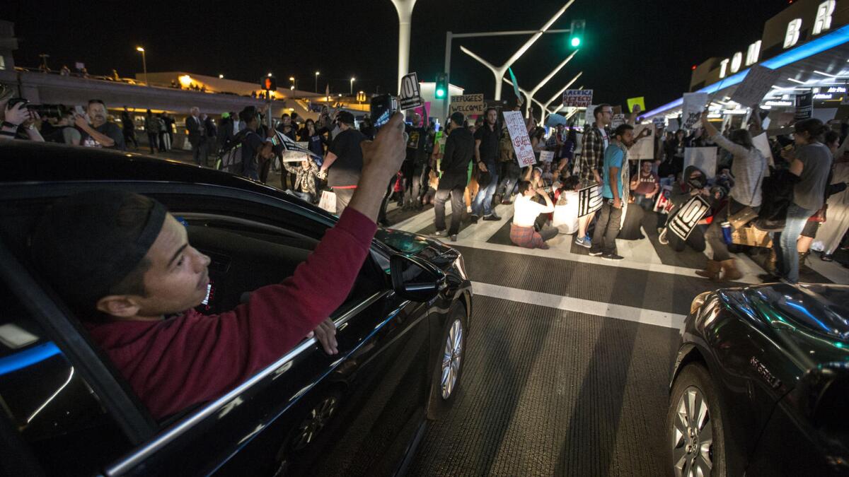 Protesters of President Trump's immigration order block traffic at LAX.