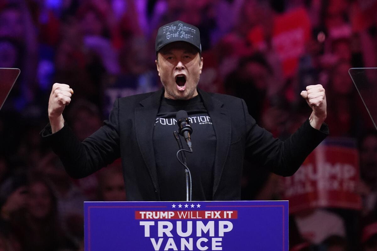 Elon Musk flexes and shouts into a microphone at a Trump-Vance rally