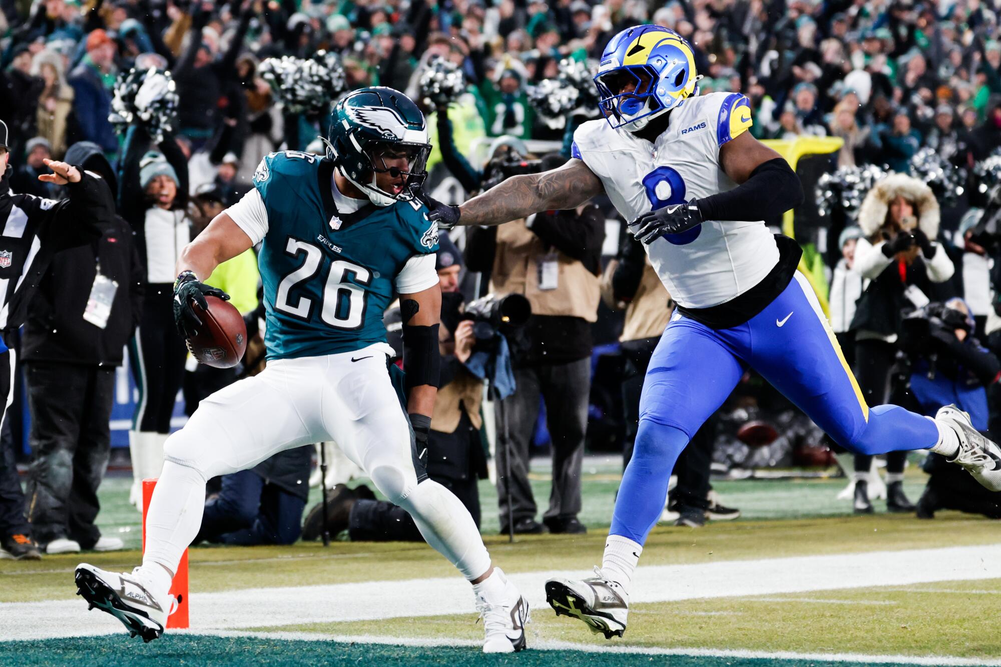 Eagles running back Saquon Barkley scores on a 62-yard touchdown run in front of Rams linebacker Jared Verse.