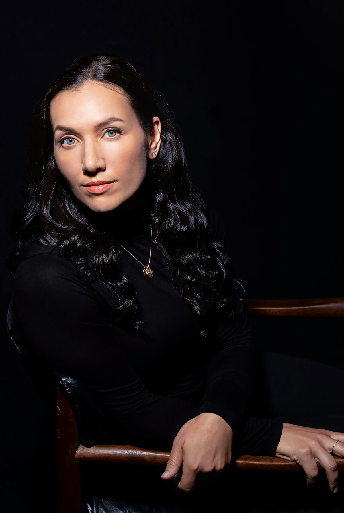 Melissa Febos, in a black turtleneck, leans in her chair.
