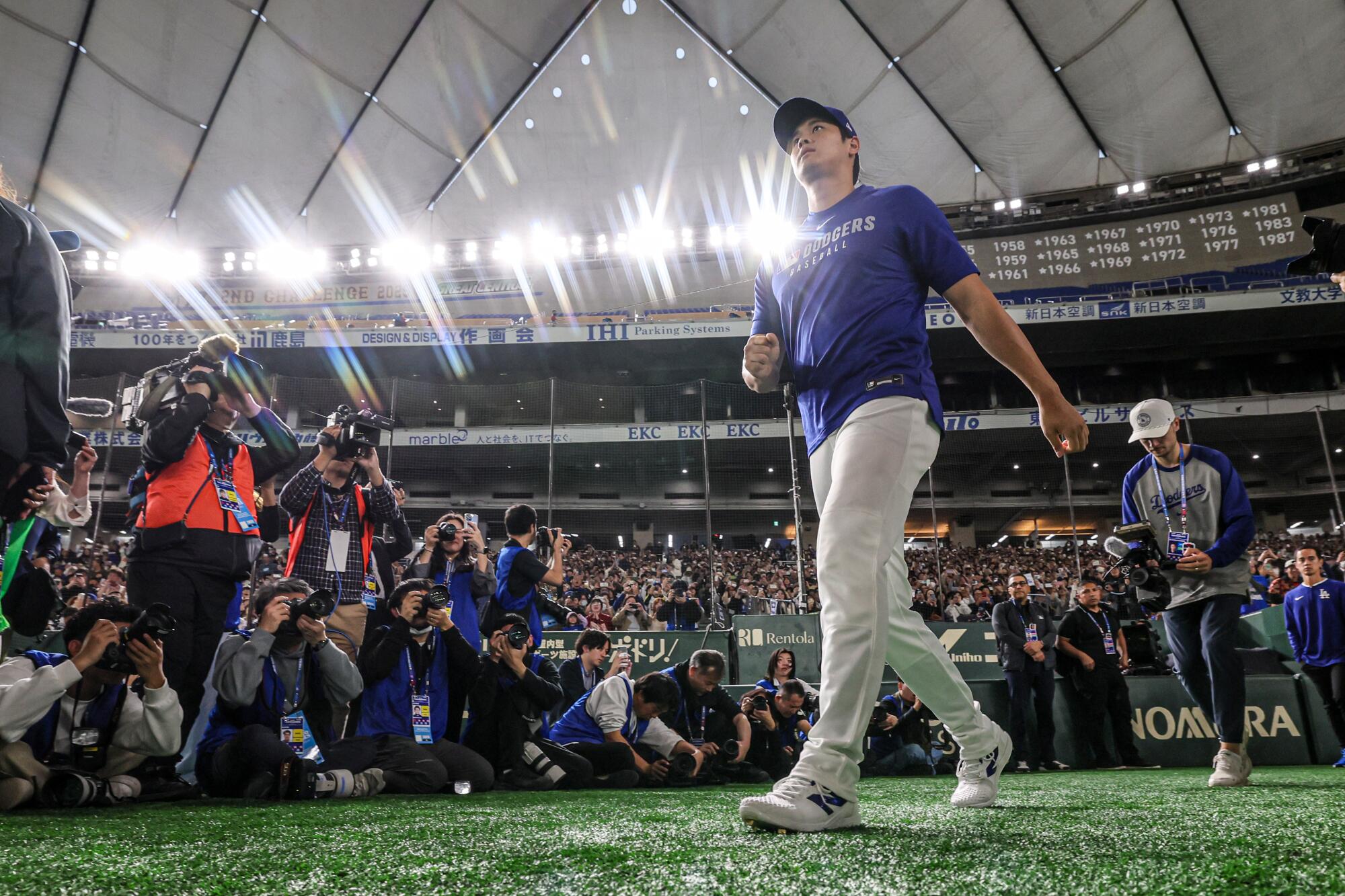 The Dodgers' Shohei Ohtani enters the field at the Tokyo Dome for a workout on Friday ahead of next week's Tokyo Series.