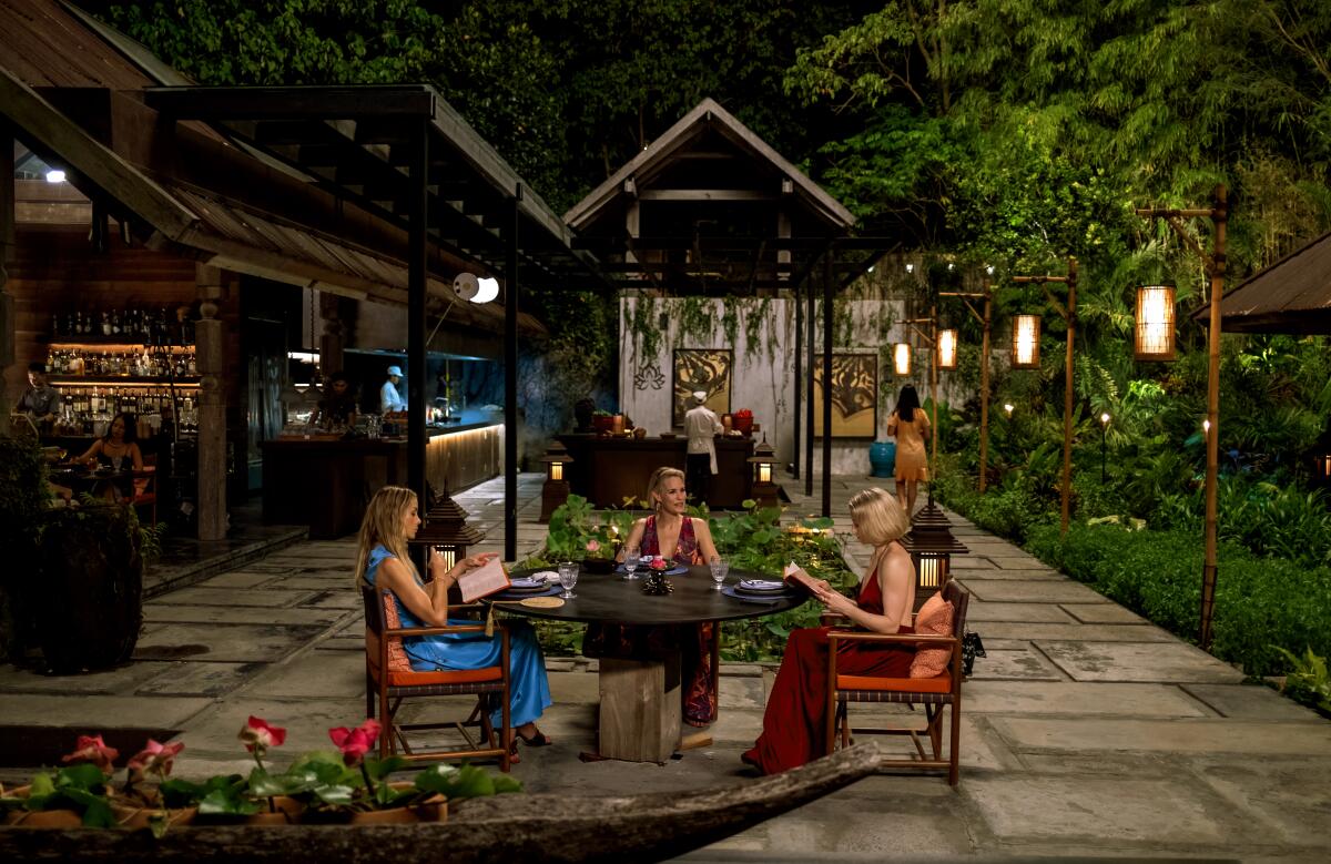 Three women seated at a dinner table.