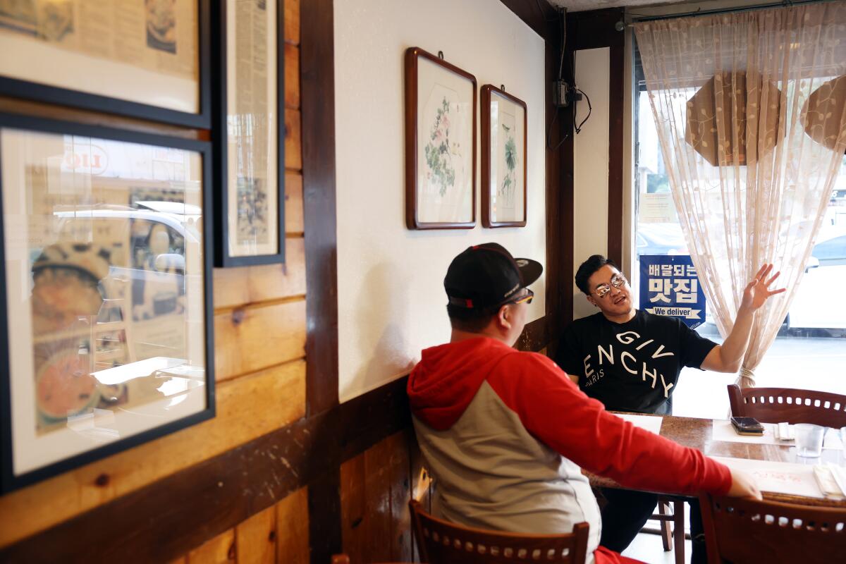 Brian Oh, left, and Ro Chei eat at a restaurant in Los Angeles.