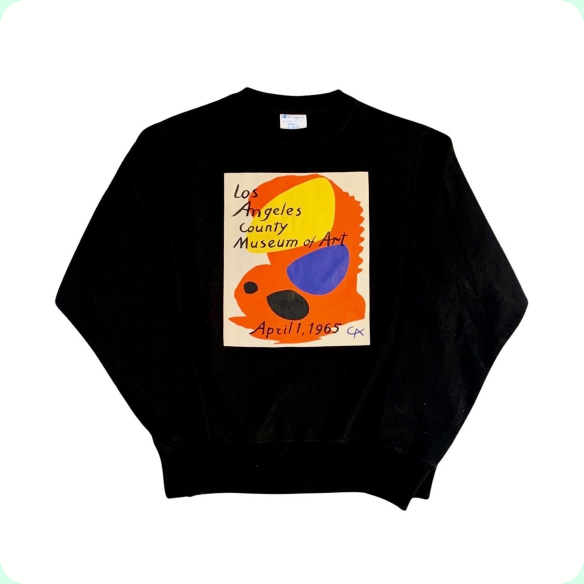 A cream colored shirt with abstract colors and text that reads "Los Angeles County Museum of Art; April 1, 1965."