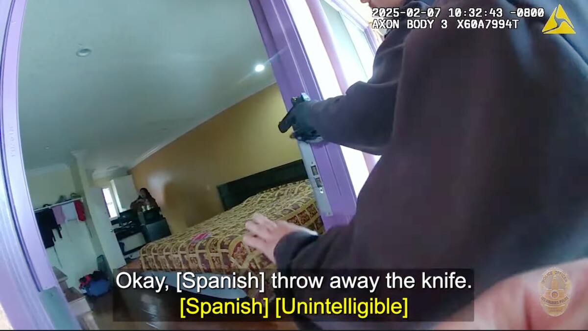 An image from video shows a police officer in a doorway holding up a gun.