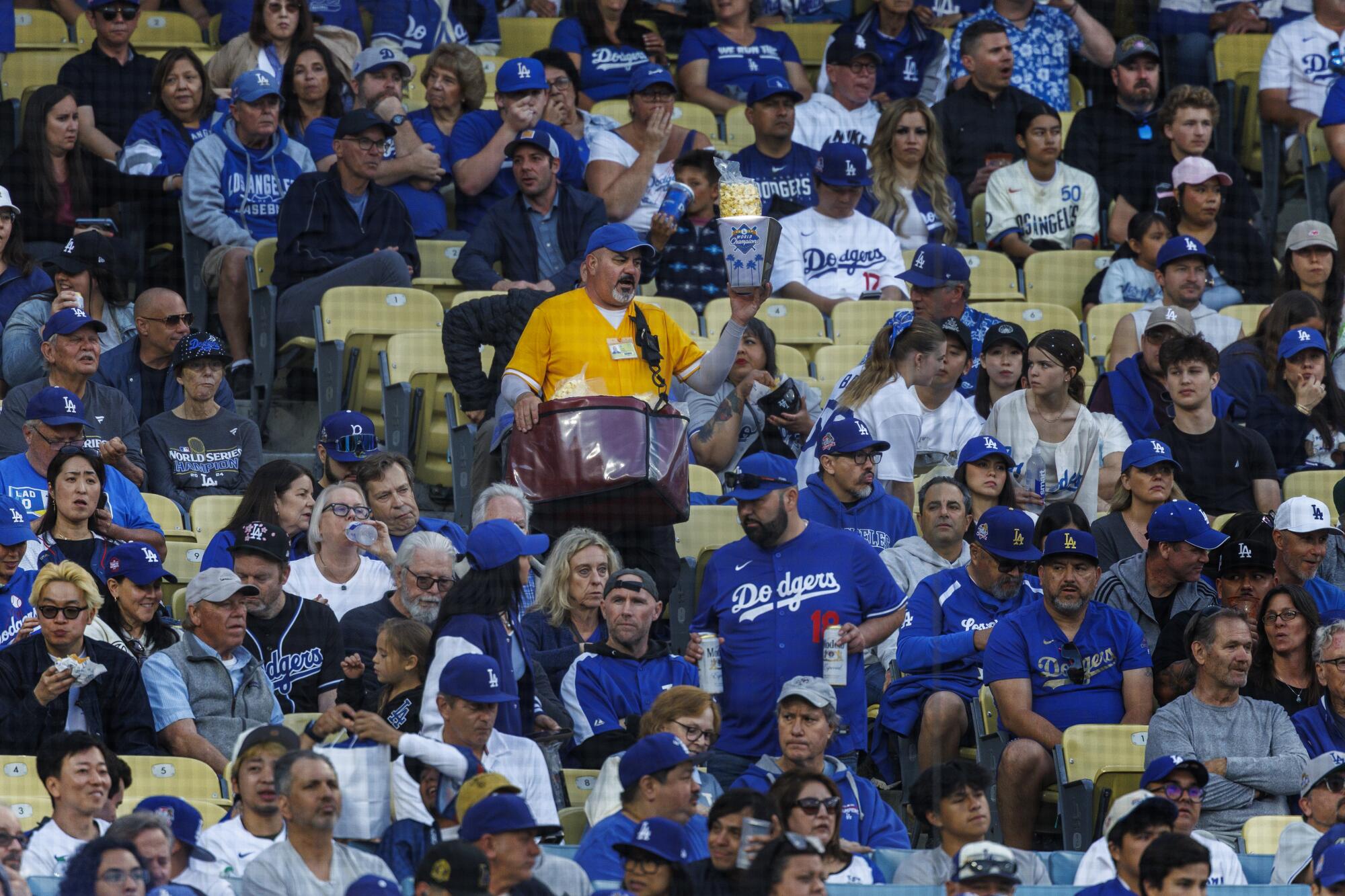 A vendor hawks popcorn while walking down the aisle during a Dodgers game against the Chicago Cubs on April 12.