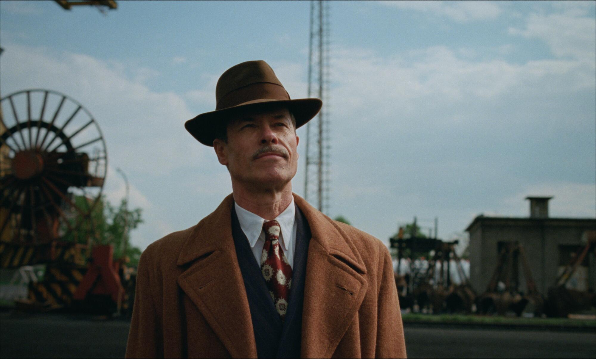 A man in a fedora hat scans the horizon.