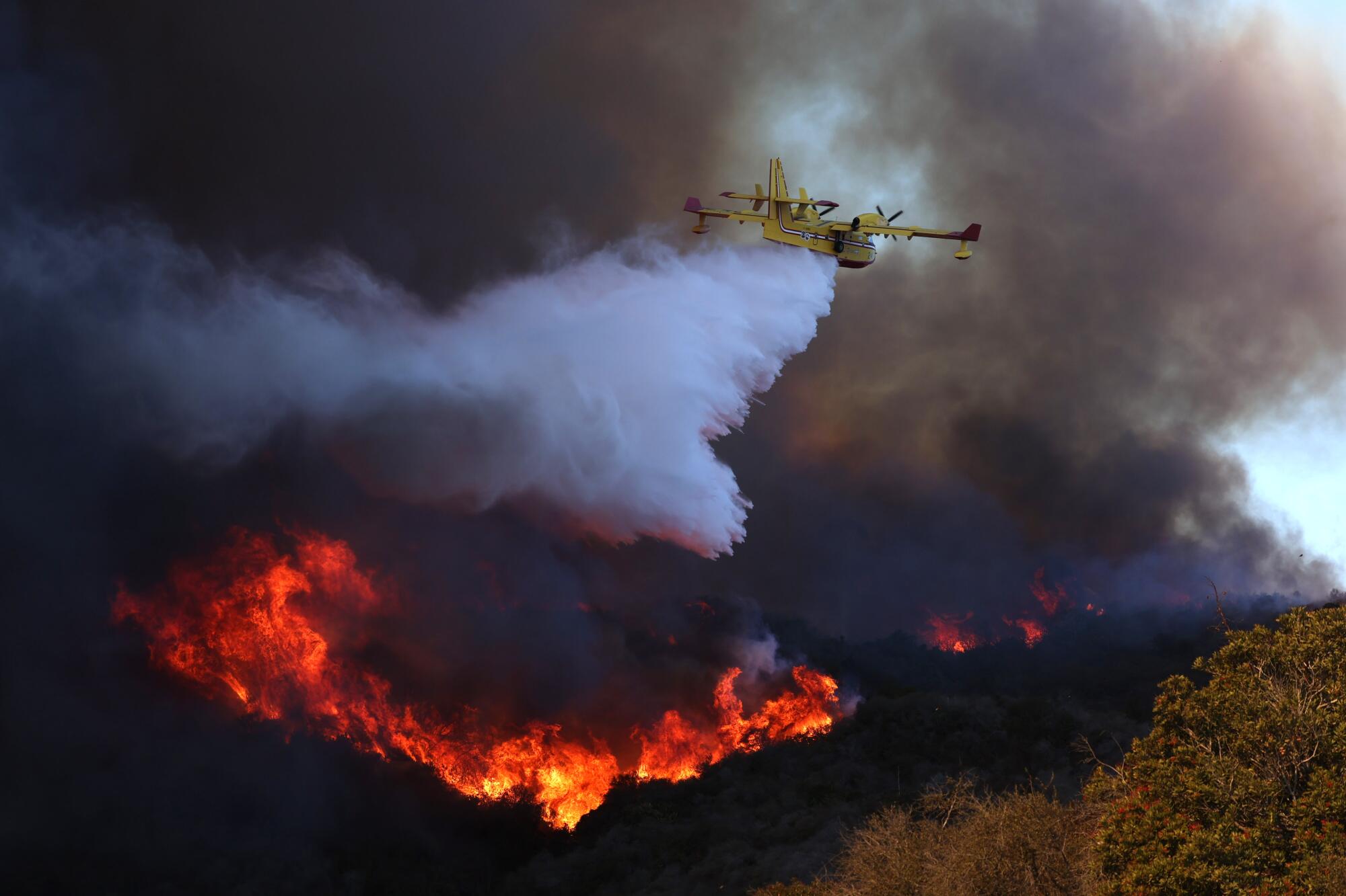 A firefighting plane makes a water drop on the Palisades fire in Pacific Palisades on Jan. 7.